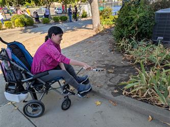 satudent in wheelchair watering plants