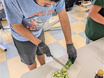 a student slices a cucumber