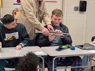 blind student being shown a trumpet