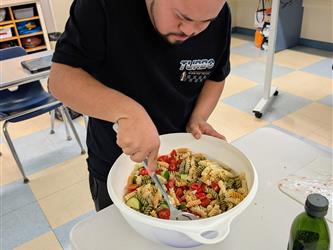 a student stirs food during a cooking project